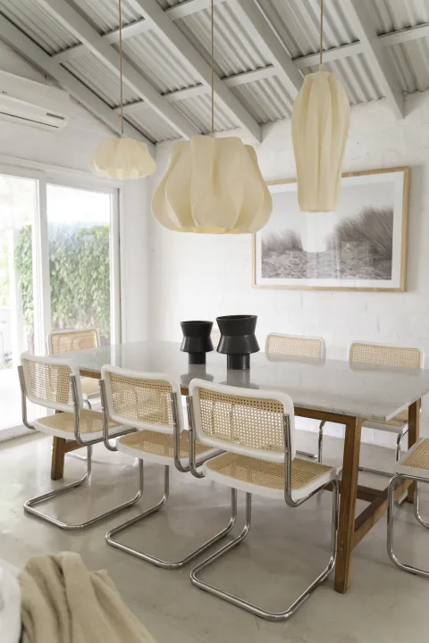 Una casa simple y funcional en Tigre donde el monocromo funciona muy bien Las lámparas del comedor son obras de una artista que emula distintas semillas en gran escala (Yolegmma Marquez Studio).
