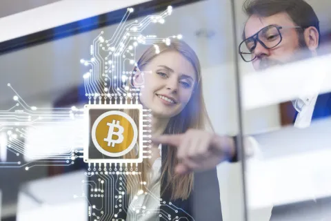 Semana Santa: el dólar cripto, entre las opciones para cuidar los ahorros estos días sin banco Dos personas interactúan con tecnología