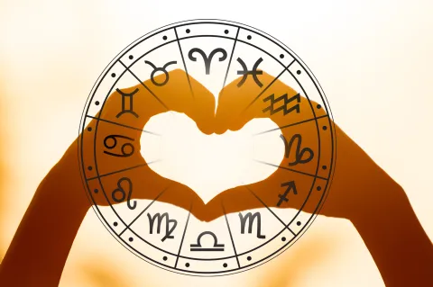 Horóscopo del amor del 28 al 30 de junio: qué signos se enamorarán este fin de semana Manos formando un corazón ante la rueda zodiacal de los signos.