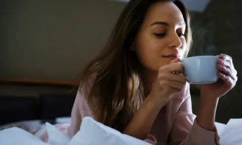 Estos son los 7 tés con mayores beneficios para tu salud mujer tomando un té en la cama.