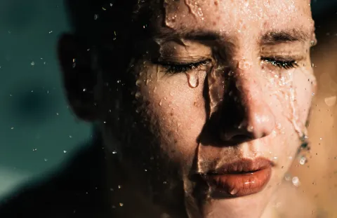 Agua marina en tu rutina de skincare: ¿cuáles son sus beneficios para la piel? Mujer con el rostro salpicado de agua.