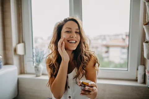 Belleza de invierno: 5 productos de cosmética natural que nos encantan para cuidar la piel Mujer aplicándose crema