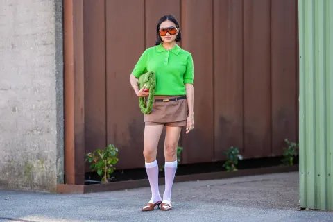 Alerta tendencia 2025: vuelve el cuello polo y así lo podés lookear en tus outfits Mujer invitada a un desfile de la semana de moda en Copenhagen.