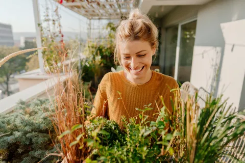 Cómo crear un jardín increíble en un balcón de pocos metros con ideas simples Mujer en un jardín.