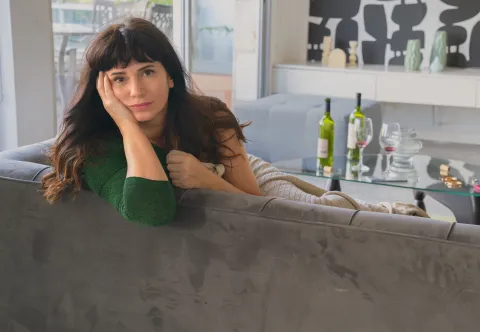 Alerta tendencia 2025: el look total denim de Griselda Siciliani que anticipa lo nuevo en moda Griselda Siciliani posando en un sillón con un vestido verde en la serie Envidiosa de Netflix
