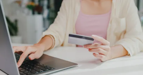 Cuotas sin interés: cómo comprar online y ganarle a la inflación Una mujer haciendo una compra online con una tarjeta de crédito en la mano