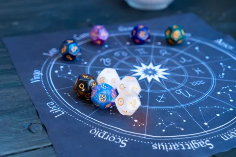 Horóscopo de octubre 2024: estas son las predicciones mensuales para todos los signos La rueda zodiacal, con los símbolos de los 12 signos astrales en un lienzo y encima, unos dados de planetas.