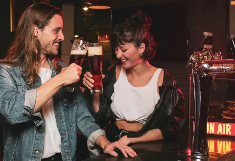 Día de la Primavera: estos son los mejores planes gastronómicos para celebrar con sorpresas Pareja brindando con cerveza y riendo.