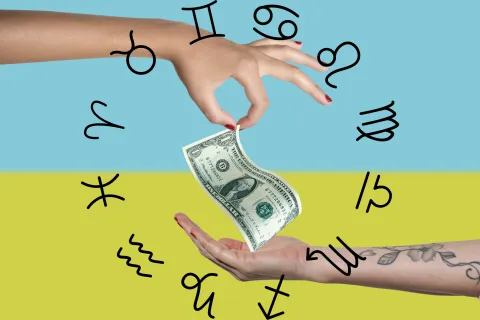 Horóscopo del dinero de septiembre: así le irá a cada signo con las finanzas este mes Unas manos sosteniendo un billete de dólar y la rueda zodiacal alrededor.