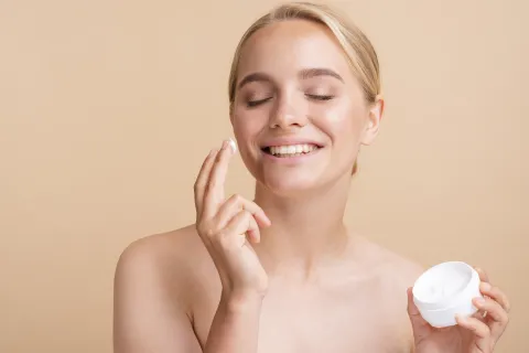 Buenas, bonitas y baratas: 7 cremas faciales ideales para hidratar bien la piel Foto de una mujer poniéndose crema hidratante en el rostro.