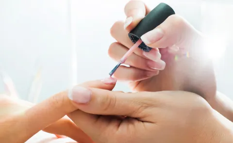 Una mujer pintándose las uñas