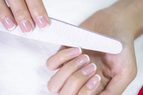 Uñas cortas que parecen largas: este es el truco para conseguirlas Una mujer limandose las uñas