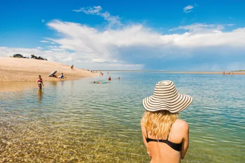 La playa escondida que es considerada el “Caribe argentino” y enamora a los turistas con sus aguas cristalinas Una mujer en la playa de espaldas con un sombrero
