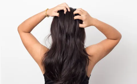 Salud capilar: cómo cuidar tu pelo de la pérdida del colágeno, después de los 25 Una mujer lavándose el pelo