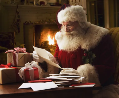 6 lugares donde podés dejarle la carta a Papá Noel y festejar Navidad Papá Noel lee una carta en vísperas de Navidad.