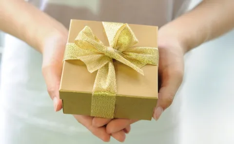 Buenos, bonitos y baratos: 20 regalos navideños por menos de 25 mil pesos una mujer con un regalo entre sus manos