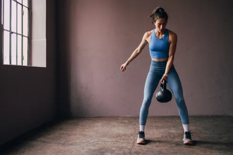 Entrená tu fuerza: ¿por qué es beneficioso hacer ejercicio físico con peso para las mujeres? Una mujer entrenando con pesas