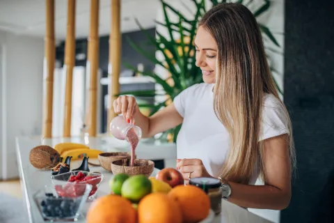 Los 5 hábitos para un desayuno saludable, según una experta Mujer desayunando frutas