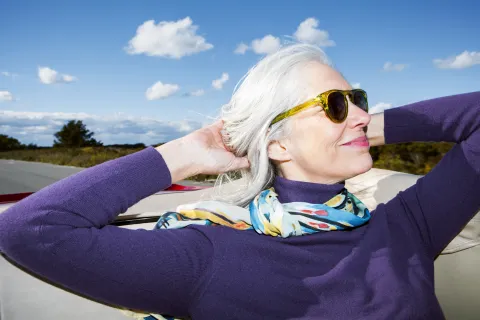 Una mujer con canas posando con su pelo largo