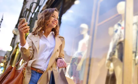 Liquidaciones de verano: estas son las 3 prendas clásicas que deberías aprovechar Una mujer haciendo shopping mirando una vidriera