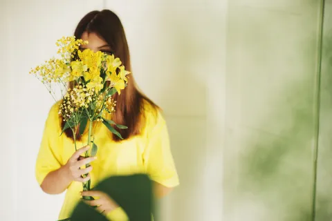 21 de marzo: ¿por qué se regalan flores amarillas? mujer con flores amarillas