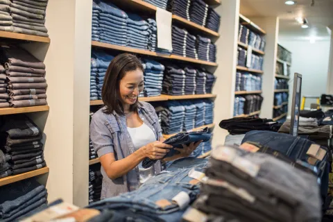 Dónde comprar jeans buenos y baratos en Avellaneda: 5 marcas de Flores recomendadas Foto de mujer comprando jeans.