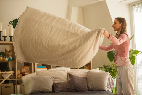 La rutina de 5 minutos que ordena tu día Foto de mujer ordenando su hogar.