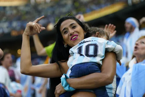 Qué dice la Psicología del Mundial: por qué el fútbol nos une, nos emociona y nos representa mujer con hijo alentando a la selección
