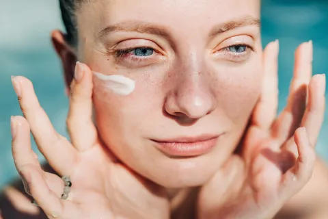 Pocos lo saben: la guía definitiva para elegir tus activos de skincare y aprender a combinarlos Una mujer poniendose una crema en la cara