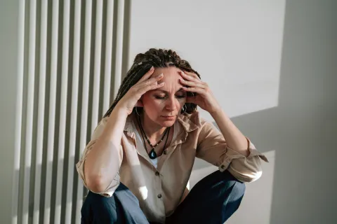 mujer con niebla mental se toma la cabeza