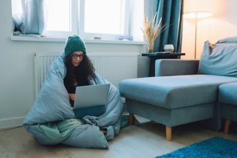 Cómo aislar puertas y ventanas con materiales reciclados: trucos caseros para el frío de julio Foto de mujer en invierno.