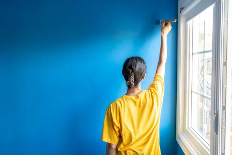 Cuánto cuesta pintar una habitación en junio de 2026: guía de precios y consejos Foto de mujer pintando.