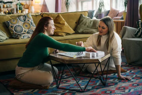 dos chicas juegan a juego de mesa
