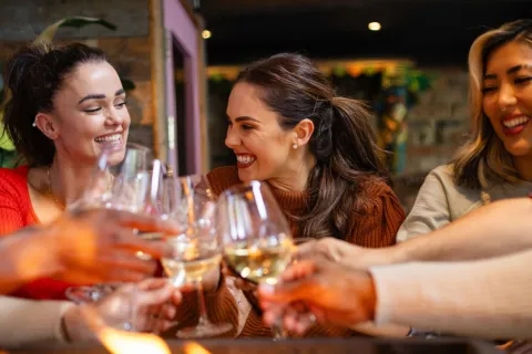 Pocos saben: cómo se logra que un vino tenga 0% alcohol mujeres brindan con vino y sonrien