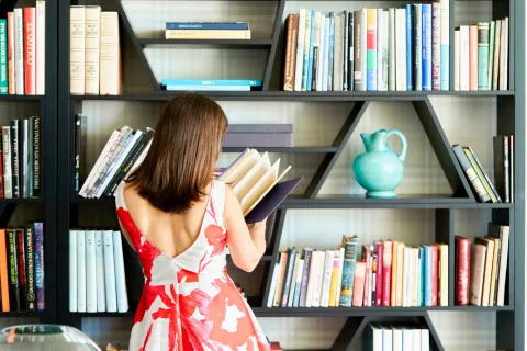 Bookshelf wealth: la tendencia de decorar con libros reales que conquista los livings Foto de mujer leyendo un libro.