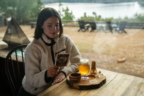 Día Internacional de la Cerveza: por qué se celebra hoy y 7 lugares para brindar con el maridaje perfecto mujer bebe cerveza en un bar