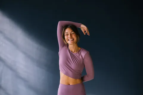 Las mejores prendas para entrenar en invierno: dónde encontrarlas Una mujer haciendo un estiramiento con ropa deportiva