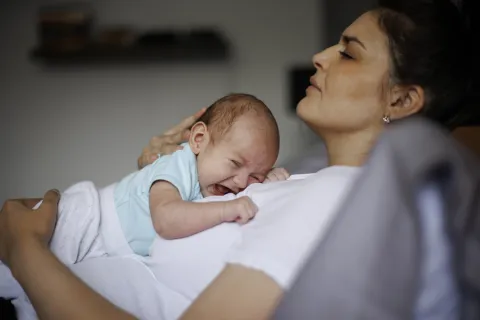 Maternidad real: ni romantizarla ni demonizarla, ¿dónde quedan los grises? mamá cansada con bebé que llora