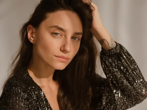 Cómo maquillar las cejas sin exagerar: qué recomiendan los maquilladores expertos Una mujer posando con un traje con brillos y cejas prominentes