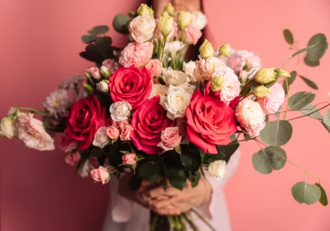 Llegó la primavera: 3 rituales ideales para renovar la energía y darle bienvenida a lo nuevo Una mujer con un ramo de flores en la mano- son rosas blancas y rojas