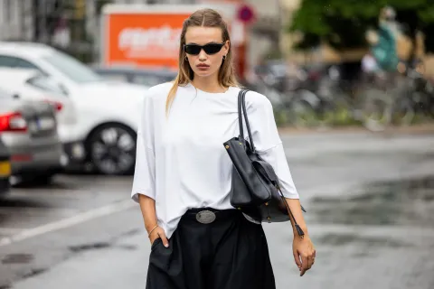 Básicos que no pasan de moda: 5 prendas en las que tenés que invertir en primavera Una joven parada en la calle con lentes de sol