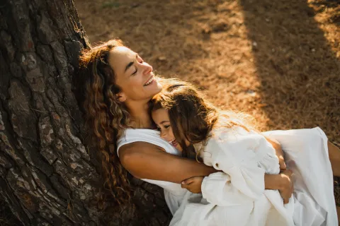 mujer con hija abrazadas