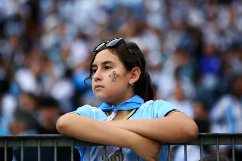 "Lloramos y no fue solo por fútbol": lo que en realidad nos pasó en la despedida de Messi Mujer joven mirando partido de fútbol con la cara pintada de Messi