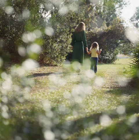 Mamá e hija caminando en la naturaleza