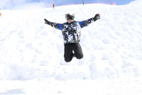 Niño saltando en la nieve