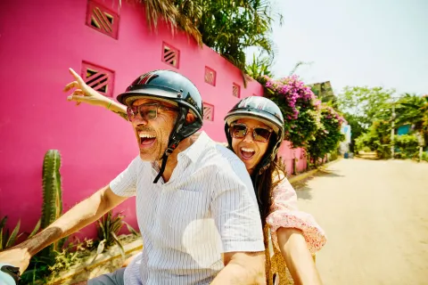 Una pareja viajando en moto sonriendo