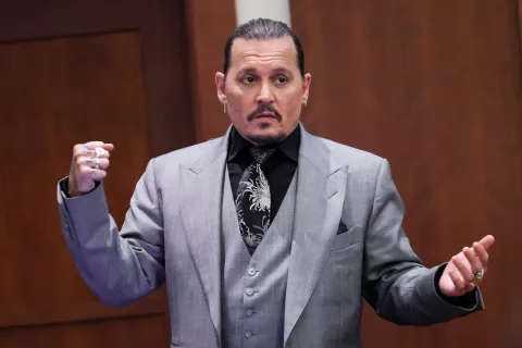 Actor Johnny Depp  demonstrates what he claims was an alleged attack by his ex-wife Amber Heard, as he testifies during the trial at the Fairfax County Circuit Court in Fairfax, Va. (Evelyn Hockstein/Pool via AP)