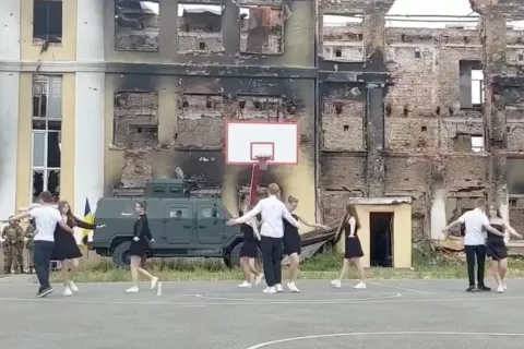 Estudiantes ucranianos bailan frente a las ruinas de su escuela. Captura de pantalla