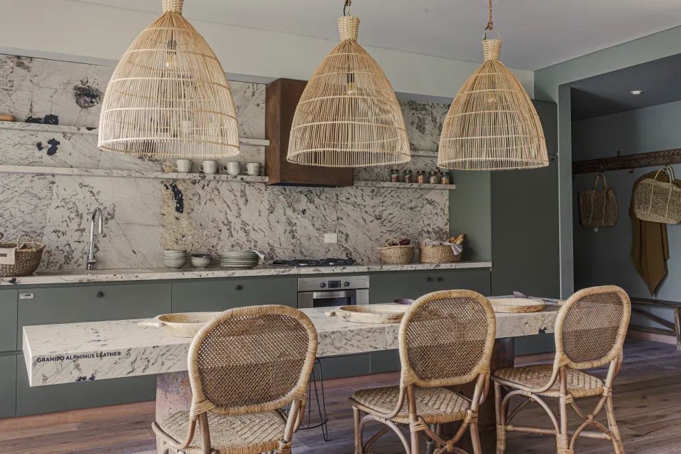 Alzada, mesada y tapa de la mesa de granito ‘Alpinus’ (Canteras del Mundo). Campana con acabado óxido (Compañía Nativa Estudio). Muebles de cocina en melamina ‘Safari’ (Faplac).