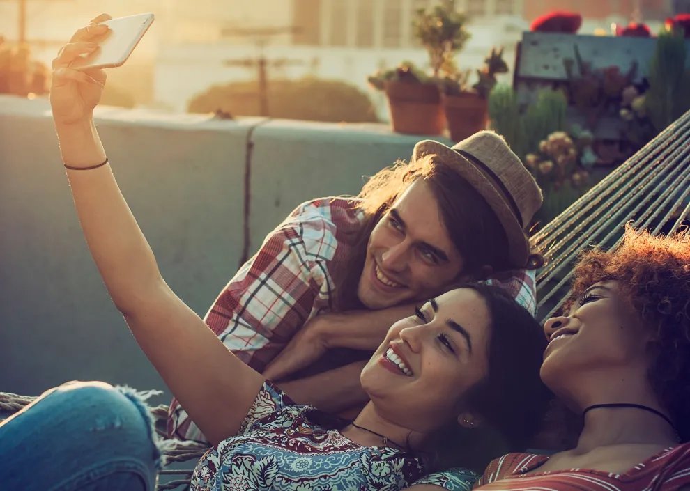 jóvenes sonriendo frente al celular